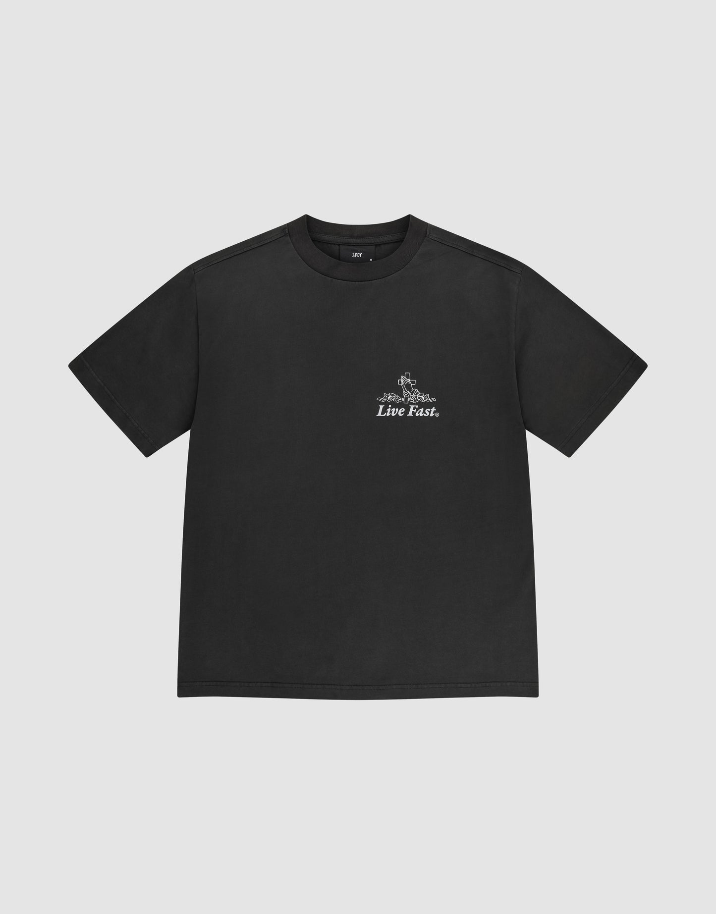 The LFDY Praying Tee by LIVE FAST DIE YOUNG is a black oversized cotton short-sleeve t-shirt featuring white “Live Fast” text and a small graphic on the left chest, shown against a plain light gray background.