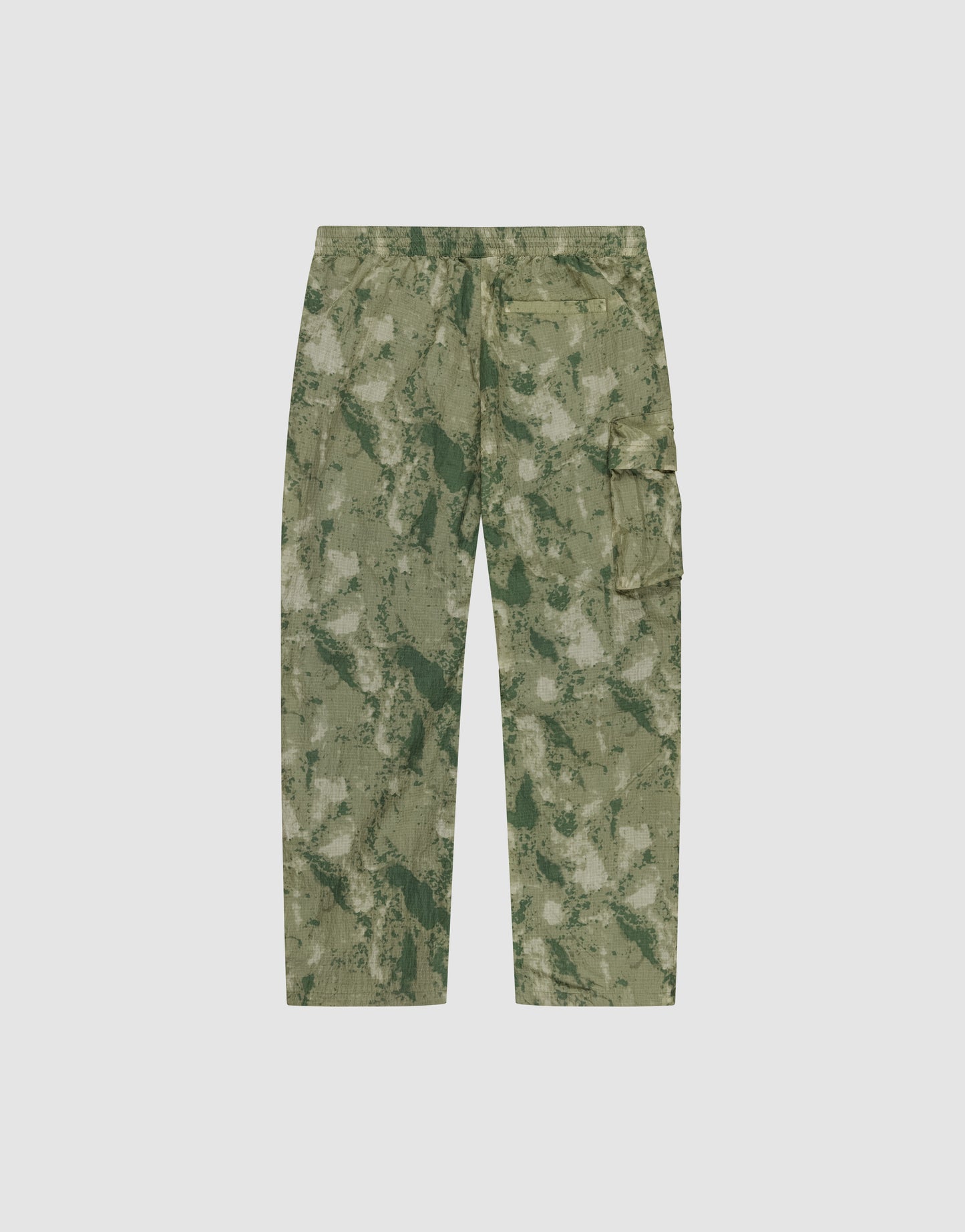 The LIVE FAST DIE YOUNG Live Fast Nylon Pants feature a relaxed oversize fit, side pockets, a utility cargo pocket, and an abstract green nylon camo design. Shown on a plain white background.