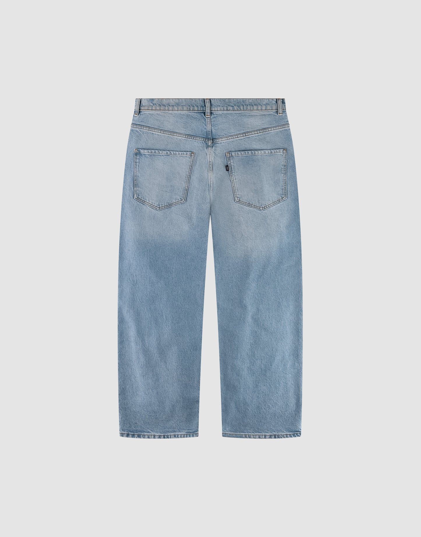 Back view of LFDY Baggy Denim by LIVE FAST DIE YOUNG in light blue with a baggy fit, wide straight leg, two back pockets, belt loops, and faded wash laid flat on a light gray background.