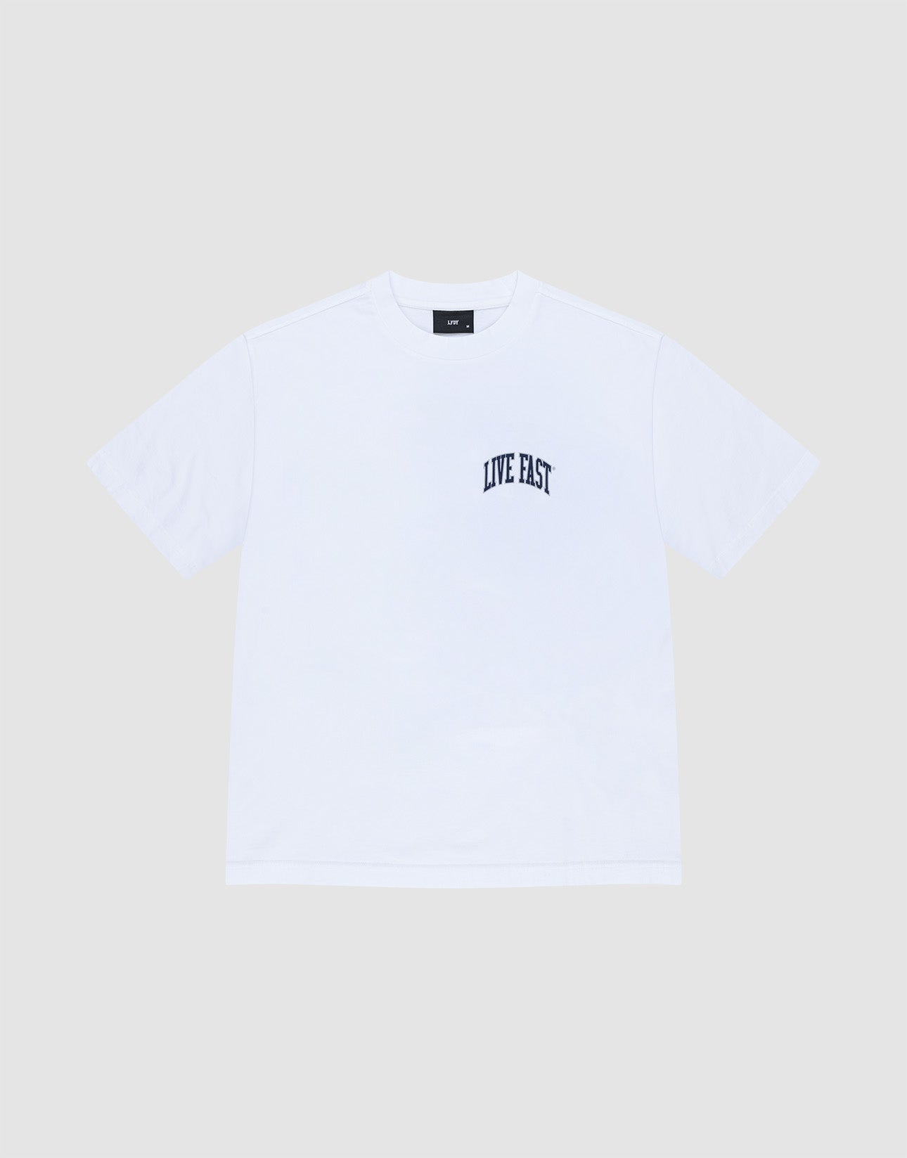 The LIVE FAST DIE YOUNG Live Fast London Tee is a plain white, oversize fit short-sleeve cotton t-shirt with "LIVE FAST" in black on the left chest, shown against a light gray background.