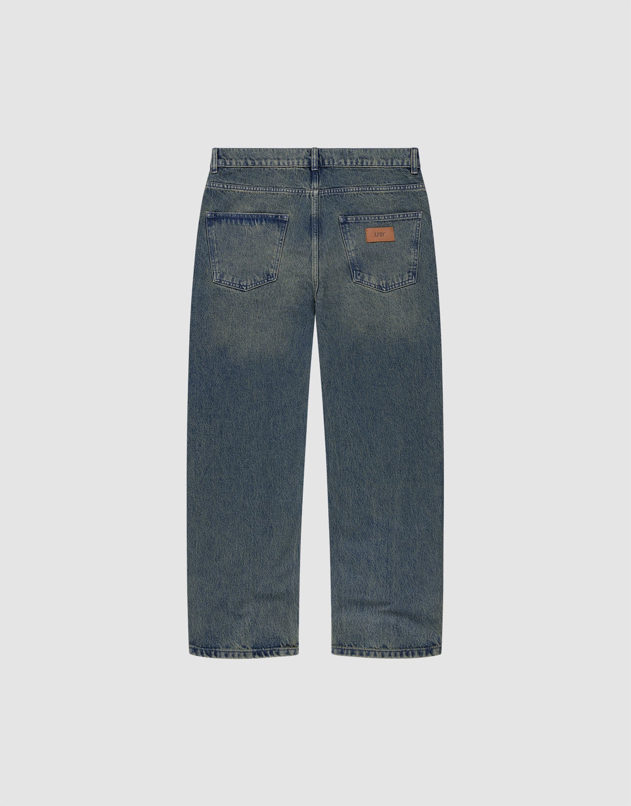 Back view of LIVE FAST DIE YOUNG Regular Denim jeans in blue, featuring two back pockets—one with a brown leather patch. Made from recycelte Baumwolle with a tapered leg, shown on a plain light gray background.