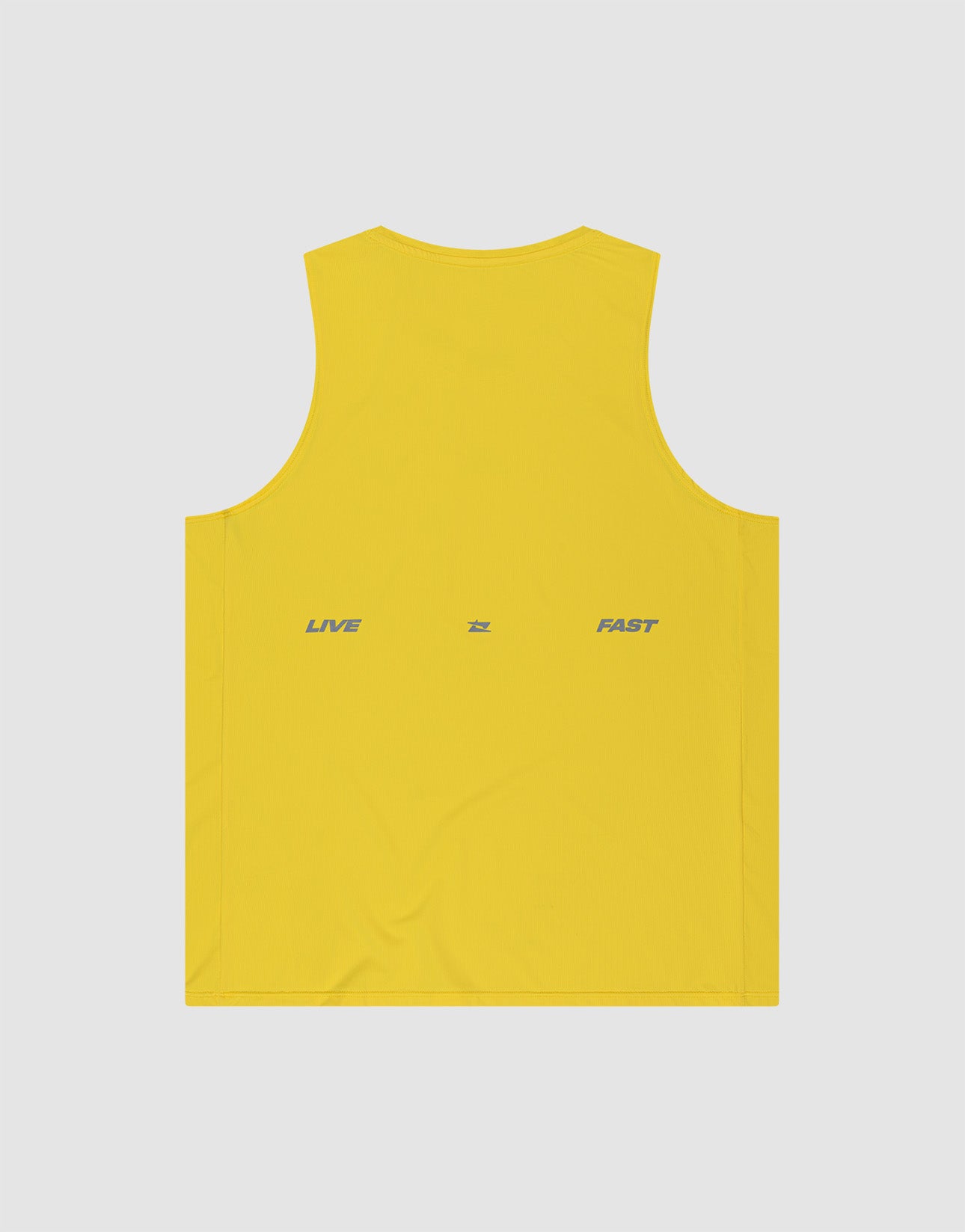 The LIVE FAST DIE YOUNG Live Fast Performance Tank is a yellow sleeveless slim fit top in nylon spandex, featuring "LIVE" and "FAST" printed in gray on the back with a small gray symbol, set against a light gray background.