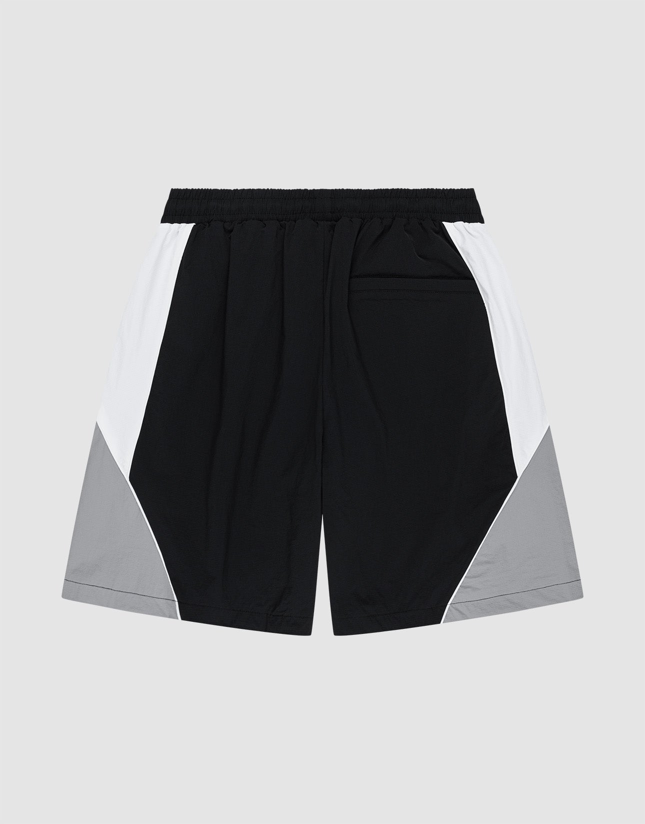 The LIVE FAST DIE YOUNG Basic Nylon Trackshorts feature a Regular Fit, elastic waistband, black color with white side panels, and light gray lower outer panels. Made from Nylon Lycra, shown laid flat on a plain light background.