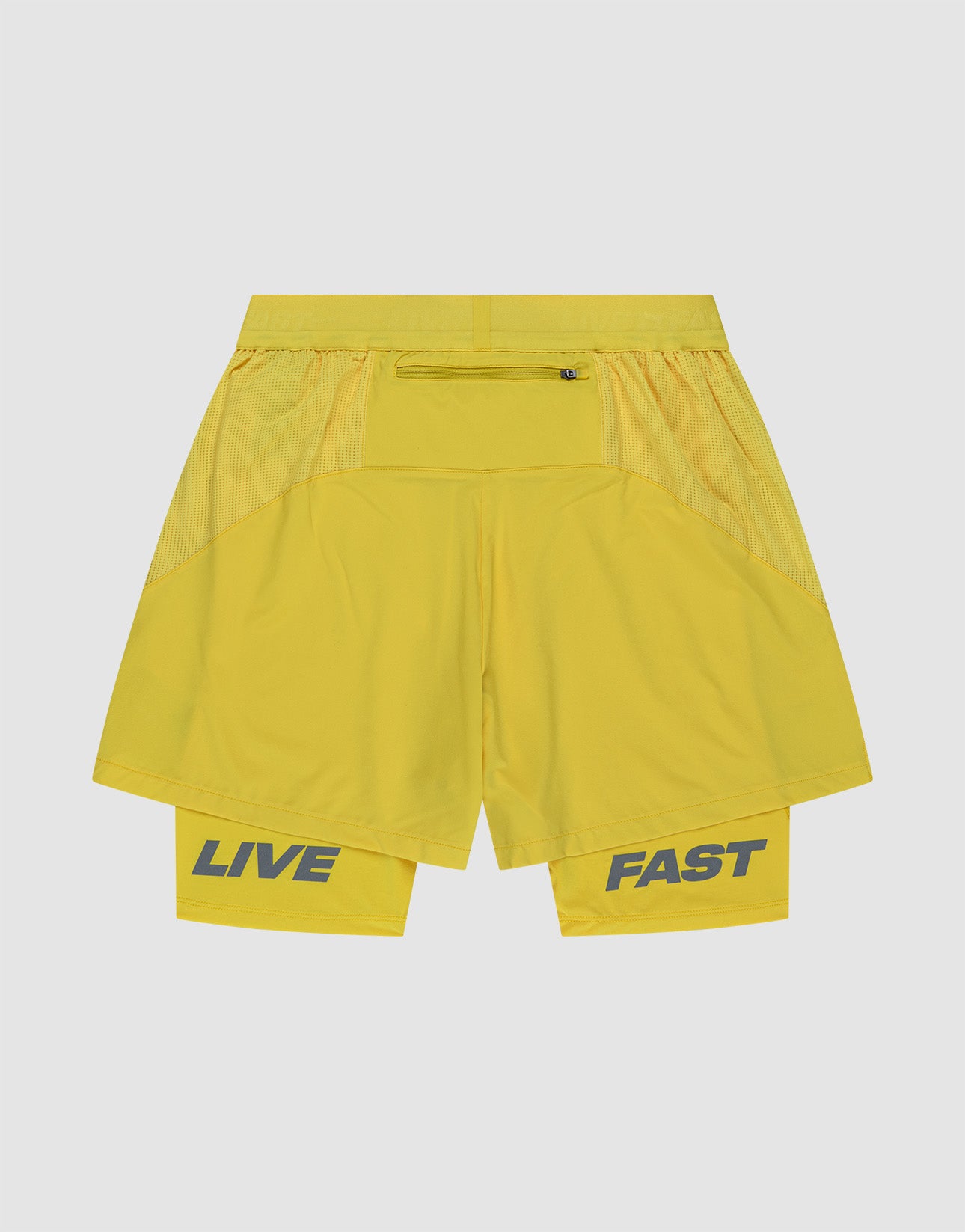 The LIVE FAST DIE YOUNG Live Fast Performance Running Shorts are yellow, Regular Fit, with a mesh Elastikbund, outer and inner tights layers. "LIVE" and "FAST" appear in bold gray on the left and right legs.