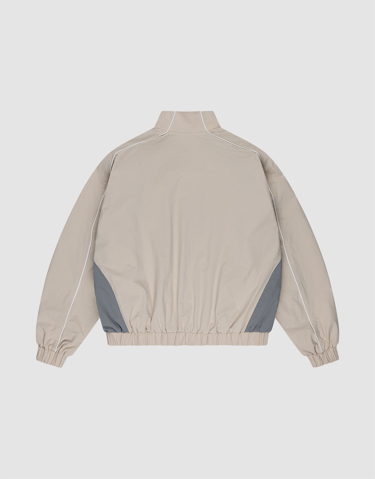 The LIVE FAST DIE YOUNG Basic Nylon Trackjacket in beige features a high collar, long sleeves with elastic cuffs, grey side panels, white piping, an elastic waistband, and a Reißverschluss. Regular fit offers versatile style and comfort.