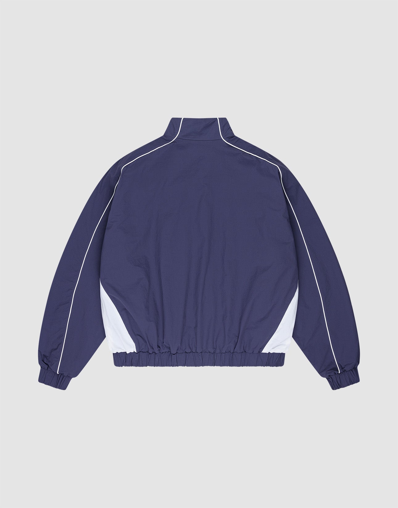 The LIVE FAST DIE YOUNG Basic Nylon Trackjacket in navy blue features a regular fit, white side panels and piping, high collar, elastic waistband and cuffs, plus a subtle logo-stitch detail. Shown on a plain light gray background.