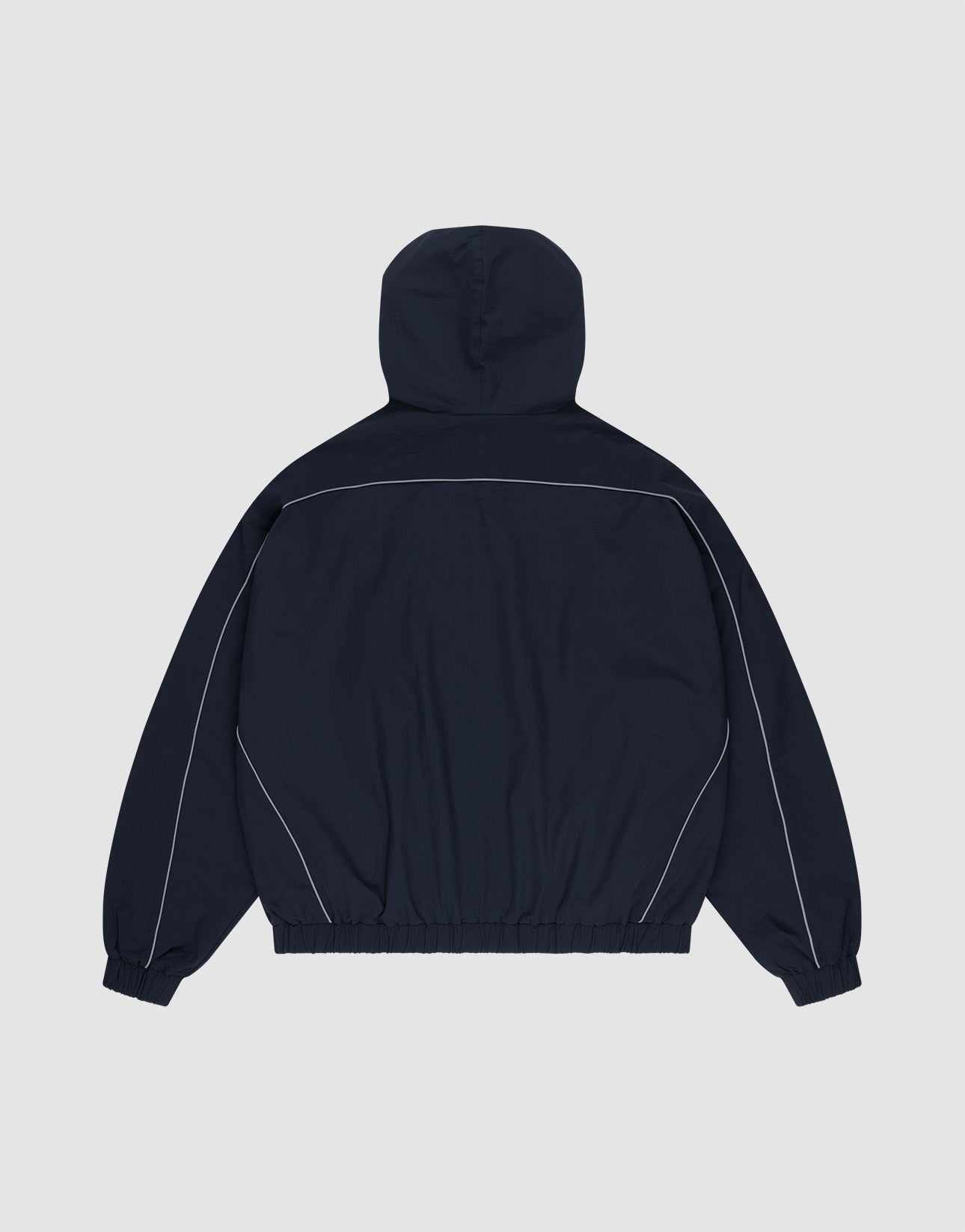 The Live Fast Trackjacket by LIVE FAST DIE YOUNG is a navy blue nylon jacket, shown from the back with white piping on shoulders and sleeves, reflective print details, plus elastic cuffs and waistband for a comfy regular fit.