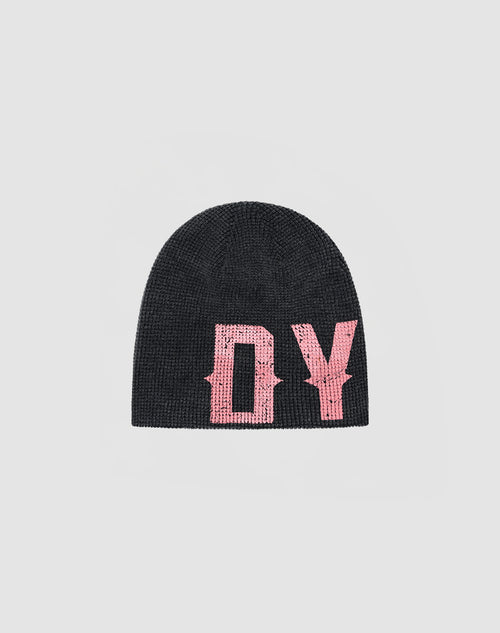 The DY Waffle Beanie by LIVE FAST DIE YOUNG is a black knit hat with bold pink stylized “DY” letters in a spray effect on the front, displayed on a simple light gray background.