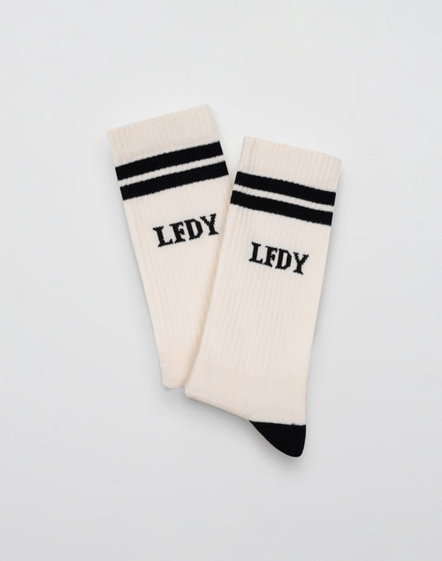 A pair of LIVE FAST DIE YOUNG 2 Tone Socks (2 Pack) in white Baumwolle with black toes, two black stripes near the cuffs, and LFDY in black on the front, displayed flat on a plain white background.