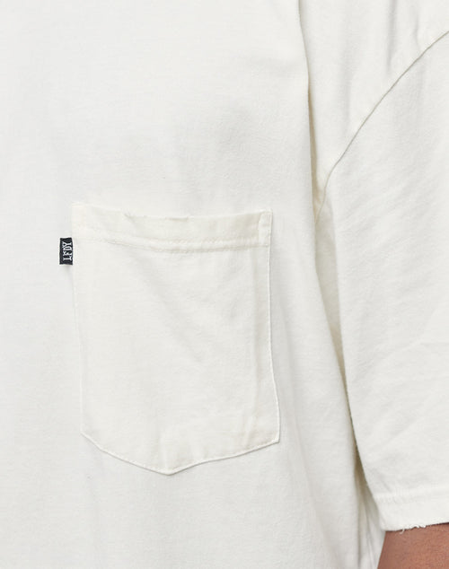 Close-up of the LFDY Destroyed Pocket Tee, a white oversized T-shirt featuring short sleeves, a left chest pocket, and a small black fabric tag on the pocket seam.