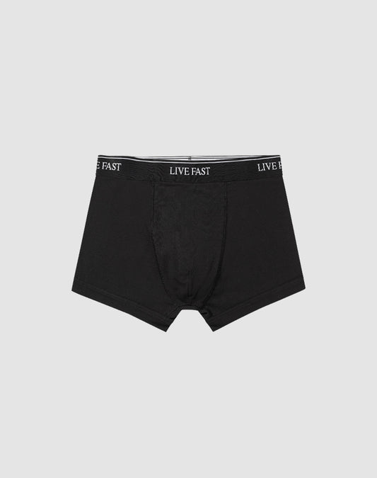 Das 2er-Set "Live Fast Trunks" von LIVE FAST DIE YOUNG bietet schwarze Herren-Boxershorts aus Baumwolle mit elastischem Bund und weißem LIVE FAST-Schriftzug, präsentiert auf schlicht hellgrauem Hintergrund.