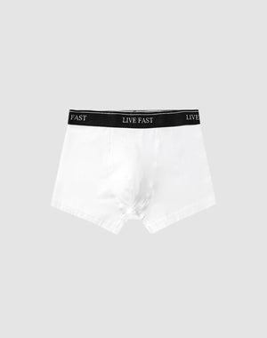 A pair of Live Fast Trunks (2 Pack) by LIVE FAST DIE YOUNG in white cotton features a black elastic waistband with LIVE FAST in white, set against a plain light gray background.