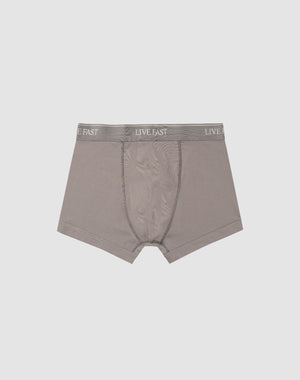 LIVE FAST DIE YOUNG’s Live Fast Trunks (2 Pack) feature soft gray cotton, a visible front pouch, and an elastic waistband with repeated LIVE FAST branding. Displayed flat on a light gray background. Care instructions included.