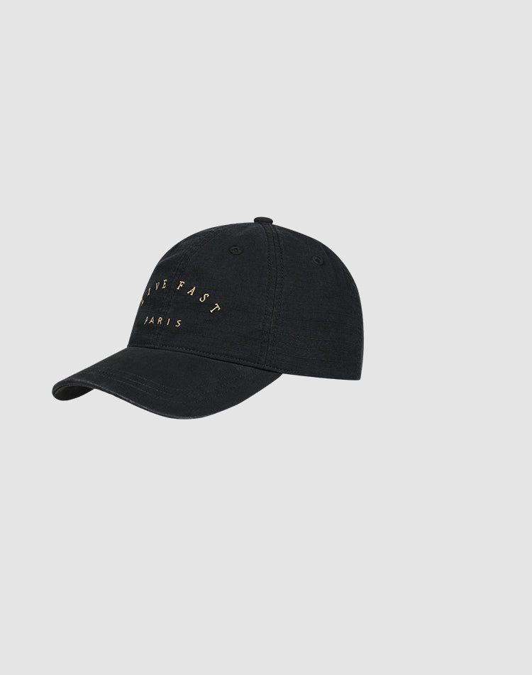 The Live Fast Paris Cap by LIVE FAST DIE YOUNG is a black 100% Baumwolle baseball cap with gold "LIVE FAST PARIS" embroidery on the front, shown against a plain light gray background.