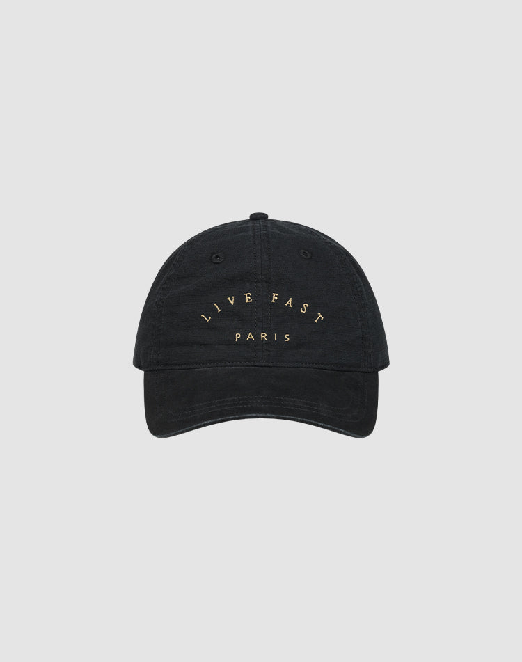 The Live Fast Paris Cap by LIVE FAST DIE YOUNG is a black 100% Baumwolle baseball cap with "LIVE FAST PARIS" embroidered in gold on the front, shown against a plain light gray background.