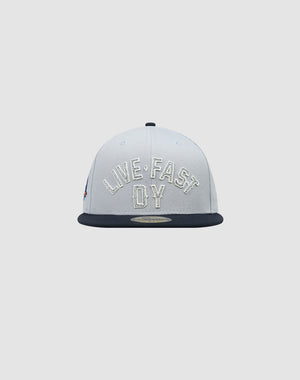 Front view of a gray LFDY X NEW ERA 59FIFTY Fitted Cap by LIVE FAST DIE YOUNG with black brim and large white LIVE FAST and DY embroidery on the front panel. Größentabelle available for sizing.