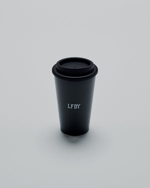 The LFDY Coffee Cup by LIVE FAST DIE YOUNG is a black double-walled to-go cup with a black plastic screw cap and LFDY in white on the front, shown against a plain light gray background.