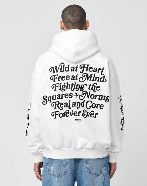 Wearing the LFDY Ultra Hooded by LIVE FAST DIE YOUNG, this person faces away in an oversize white hoodie with bold black "Wild at Heart Free at Mind Fighting the Squares + Norms Real and Core Forever & Ever" text. Limited edition print.