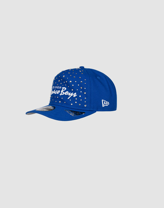 The Custom LFDY X NEW ERA Monaco Boys Cap by LIVE FAST DIE YOUNG is blue with silver studs, a white Disco Boys script, curved visor, Retro Crown fit, embroidered New Era logo on the side, and a light gray background.