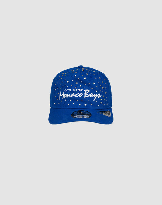 The LIVE FAST DIE YOUNG Custom LFDY X NEW ERA Monaco Boys Cap features silver studs and white text on blue, styled in handdekorierte Caps fashion, shown against a plain light gray background.