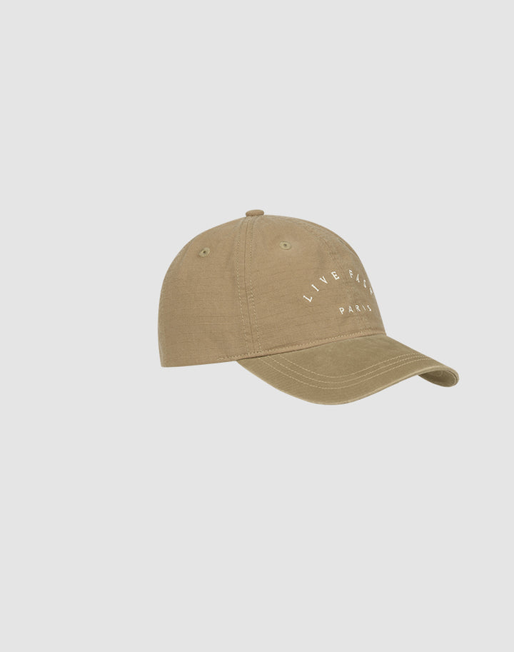 The Live Fast Paris Cap by LIVE FAST DIE YOUNG is a khaki 100% Baumwolle baseball cap featuring "LIVE FAST PARIS" in white text on the front, shown against a plain light gray background.