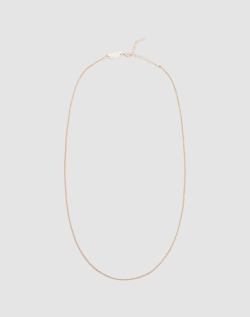 The LIVE FAST DIE YOUNG Thin Curb Chain is a delicate necklace crafted from 925 vergoldet Sterling Silber, featuring a fine, simple design with an adjustable length and displayed in an oval shape on a light grey background.