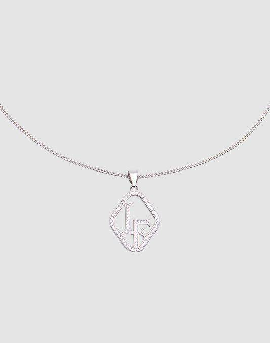 The LF Chain by LIVE FAST DIE YOUNG is a sterling silver necklace with a geometric pendant adorned with sparkling stones and stylized LF initials, featuring a zirconia charm, shown on a light gray background.