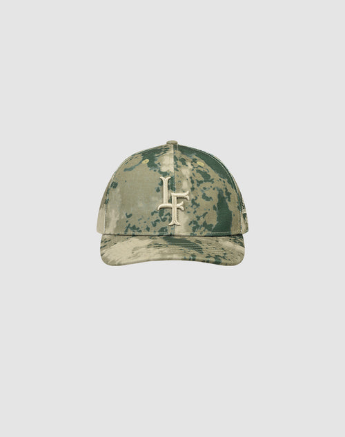 The LF Snapback by LIVE FAST DIE YOUNG is a camouflage baseball cap with a curved brim, featuring a bold white Logo-Stick LF logo on the front. Crafted from 100% Baumwolle, it’s shown against a plain light gray background.