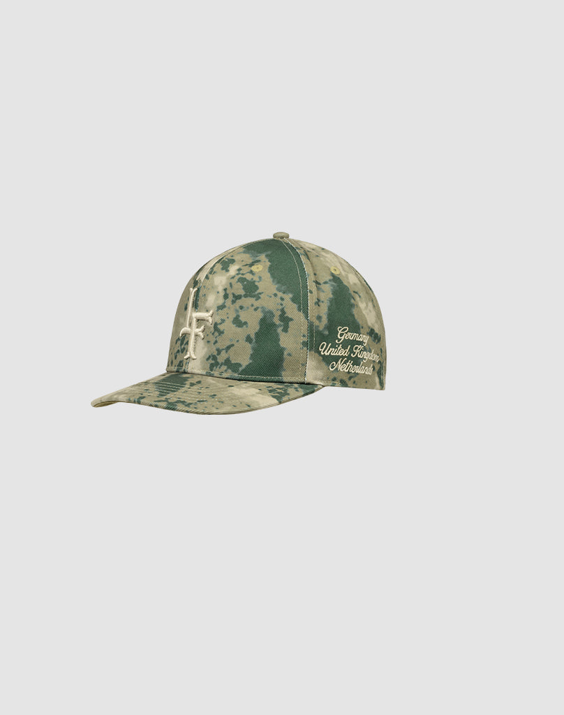 The LF Snapback by LIVE FAST DIE YOUNG is a green camouflage cap made from 100% Baumwolle, featuring an abstract light design and cursive Grateful United Times Maverick Logo-Stick embroidery on the side.