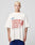 A man with short blond hair wears the LFDY Juveniles Tee by LIVE FAST DIE YOUNG, an oversized 100% Baumwolle shirt with red and blue “AMBITIOUS JUVENILES LIVE FAST DIE FAST” graphics, standing against a plain light background.