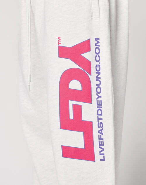 Close-up of the LIVE FAST DIE YOUNG LFDY Racing Wide Jogger in light gray, featuring a wide elastic waistband, bold pink and purple LFDY text, and “LIVEFASTDIEYOUNG.COM” printed vertically down the straight leg.