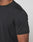 Close-up of a person wearing the LIVE FAST DIE YOUNG Live Fast Performance Tee, a fitted black short-sleeve athletic shirt made from stretchy Nylon Spandex. Only the upper torso and arm are visible against a plain light background.