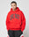 A person wears an oversize-fit red LIVE FAST DIE YOUNG Live Fast College Hooded sweatshirt and black and red athletic shorts, standing against a plain light gray background.