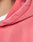 Close-up of a person wearing the Basic Hooded Zip by LIVE FAST DIE YOUNG in pink with individueller Sprayeffekt, highlighting the hood, shoulder stitching, and fabric texture. Part of the neck and a white shirt are also visible.