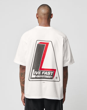 A person with short hair, seen from behind, wears an oversize white LIVE FAST DIE YOUNG LFDY Industries Tee (100% Baumwolle), featuring a large red and black L graphic and LIVE FAST INDUSTRIES text on the back (LF2406-15692).
