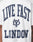 The Live Fast London Tee by LIVE FAST DIE YOUNG is a white, 100% Baumwolle T-shirt with bold navy LIVE FAST LONDON text and a central logo. It features an oversize fit, small LFDY text near the hem, and the image highlights the back.