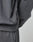 Close-up of a person in the LIVE FAST DIE YOUNG DY Sweater and matching pants. The dark gray cotton fabric shows subtle wrinkles, and a small sewn tag accents the side seam of the Raglan-sleeved sweatshirt.
