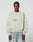 A man with braided hair wears a light green LFDY Vandals Sweater by LIVE FAST DIE YOUNG in Oversize Fit and light blue baggy jeans, standing against a plain white background.