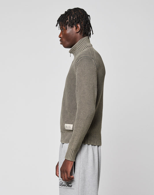 A person stands in profile wearing the LIVE FAST DIE YOUNG LFDY Knit Jacket with a stand-up collar and light gray sweatpants against a plain light gray background.