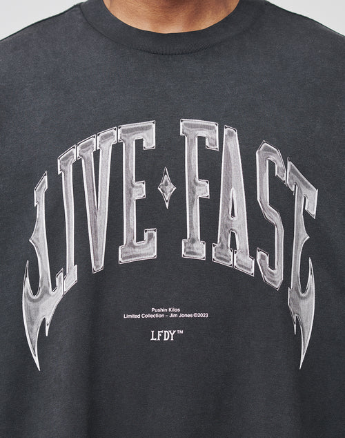 A close-up of the Live Fast Axe Tee by LIVE FAST DIE YOUNG, an oversize-fit black T-shirt with bold white LIVE FAST front print and Pushin Kilos Limited Collection – Jim Jones ©2023 LFDY™, made from high-quality cotton.