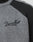 Close-up of the Boxy Knit Zip Jacket by LIVE FAST DIE YOUNG, in gray with black raglan sleeves and collar, featuring "Live Fast" embroidered in black cursive on the chest.