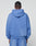 A person faces away from the camera, wearing a light blue LIVE FAST DIE YOUNG Basic Hooded Zip in an oversize fit with matching pants. The plain, light background highlights the relaxed, faded style of the look.