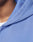 Close-up of a person wearing the LIVE FAST DIE YOUNG Basic Hooded Zip in light blue over a white shirt, showing the textured fabric, hood seam, and subtle distressing for a faded look. The edge of their face and neck is partially visible.