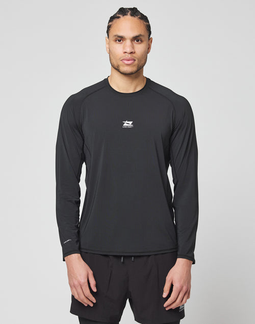 A man with braided hair wears the LIVE FAST DIE YOUNG Live Fast Performance Longsleeve in black and matching black shorts, standing facing forward against a plain light gray background.