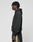 A person with short, twisted hair wears the LIVE FAST DIE YOUNG Basic Blank Hooded in an oversize fit, paired with black pants featuring a tan stripe, standing in profile against a plain light gray background.
