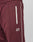 Close-up of maroon Live Fast Trackjogger by LIVE FAST DIE YOUNG, featuring a Regular Fit, white zippered pocket, white side piping, and “LIVE FAST” logo embroidered in white below the pocket.