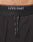 Close-up of a person’s lower torso wearing Live Fast Performance Running Shorts by LIVE FAST DIE YOUNG. The black shorts have an elastic waistband with white LIVE FAST branding and black drawstrings with white text in front.