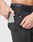 Someone wearing black Live Fast Performance Running Shorts by LIVE FAST DIE YOUNG places a smartphone in the side pocket, with a small zipper pocket and integrated tights details visible nearby.