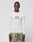 A person faces forward in a LIVE FAST DIE YOUNG LFDY Performance Slim Longsleeve, white with the number 40 on the front, and green-gray camouflage shorts made from leichtes Obermaterial, set against a plain light background.