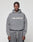 A man faces the camera in a gray LIVE FAST DIE YOUNG Basic +49 Hooded sweatshirt and matching sweatpants, featuring a bold white "+49LiveFast" front print. The background is plain and light-colored.